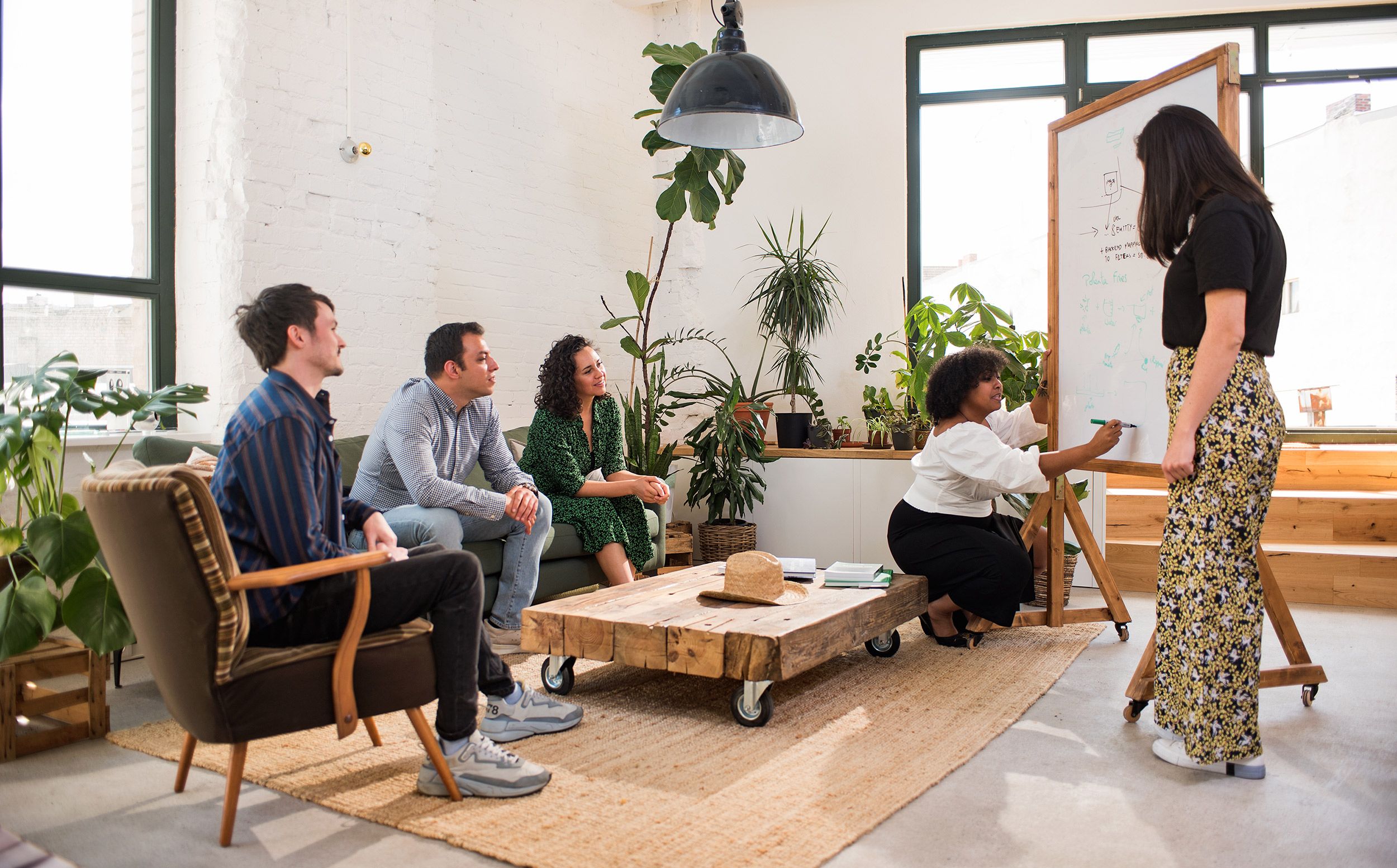 A diverse group of team members meet in the lounge to collaborate